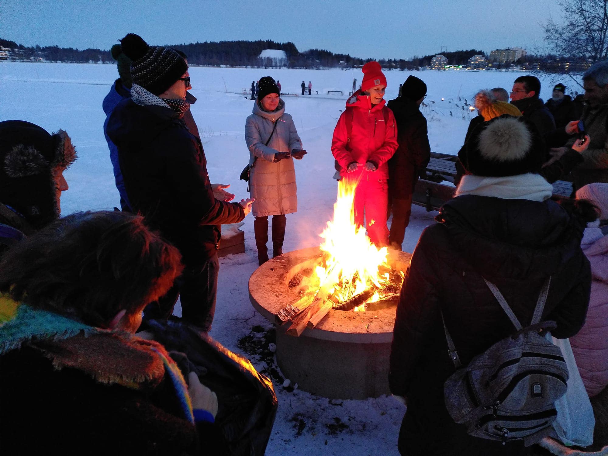 Participants warming up at a fire during the field trip as part of the Europea Seminar in Sweden, March 2023